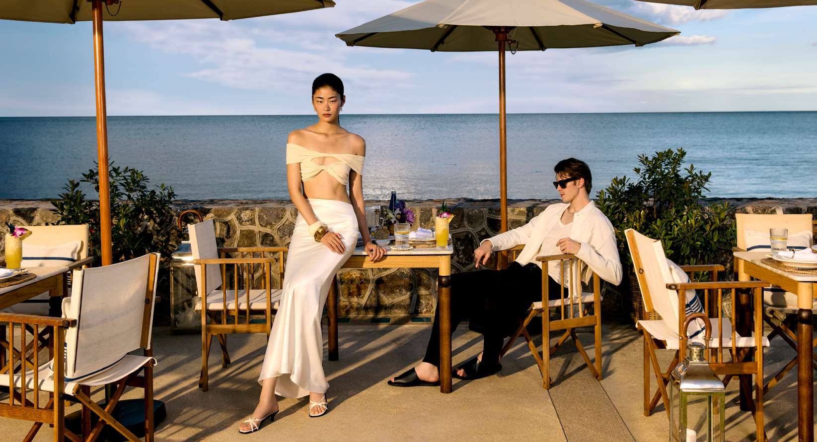 Couple dining by the ocean at sunset